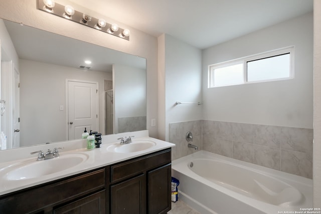 bathroom featuring a bath, tile patterned floors, and vanity