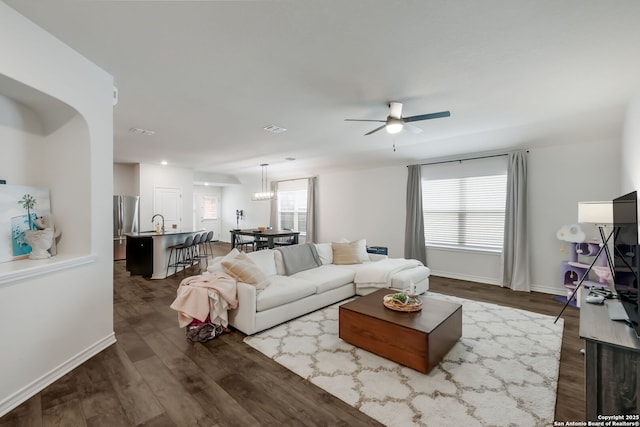 living room featuring ceiling fan, dark wood-type flooring, sink, and plenty of natural light