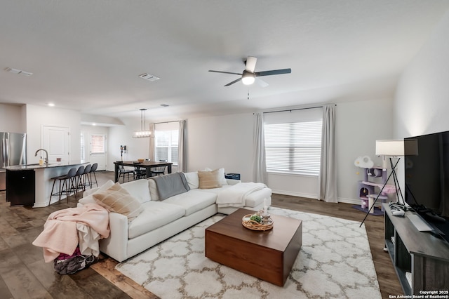 living room with ceiling fan and dark hardwood / wood-style flooring