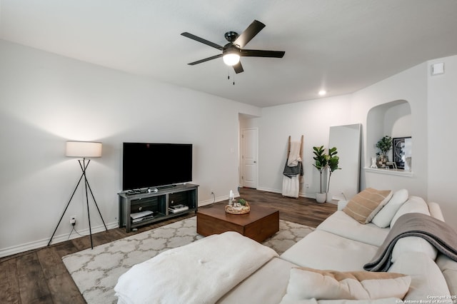 living room with ceiling fan and dark wood-type flooring