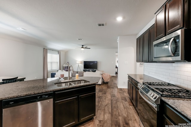 kitchen with dark hardwood / wood-style floors, sink, decorative backsplash, appliances with stainless steel finishes, and dark brown cabinetry