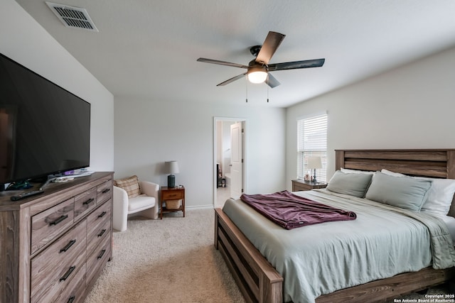 bedroom featuring ensuite bath, light colored carpet, and ceiling fan