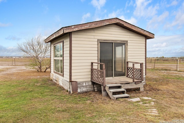 exterior space with a lawn, a rural view, and an outdoor structure