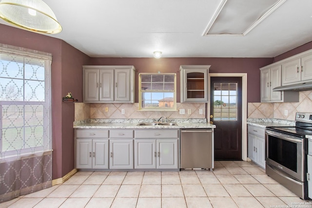 kitchen featuring light tile patterned floors, decorative backsplash, gray cabinets, appliances with stainless steel finishes, and sink