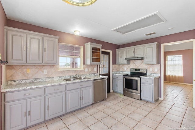 kitchen featuring gray cabinets, appliances with stainless steel finishes, light tile patterned floors, decorative backsplash, and sink