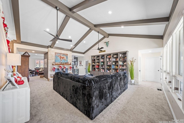 living room with a wealth of natural light, ceiling fan, lofted ceiling with beams, and carpet flooring