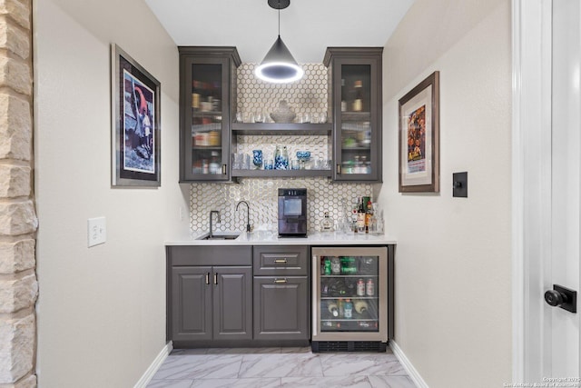 bar featuring dark brown cabinetry, wine cooler, backsplash, and sink