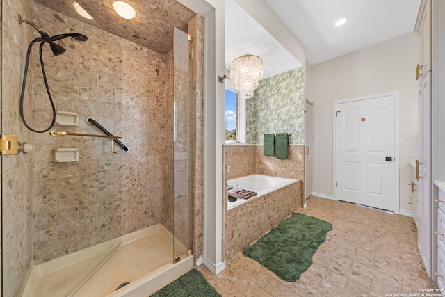 bathroom with a notable chandelier and separate shower and tub