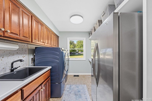 clothes washing area featuring washer / dryer, cabinets, and sink