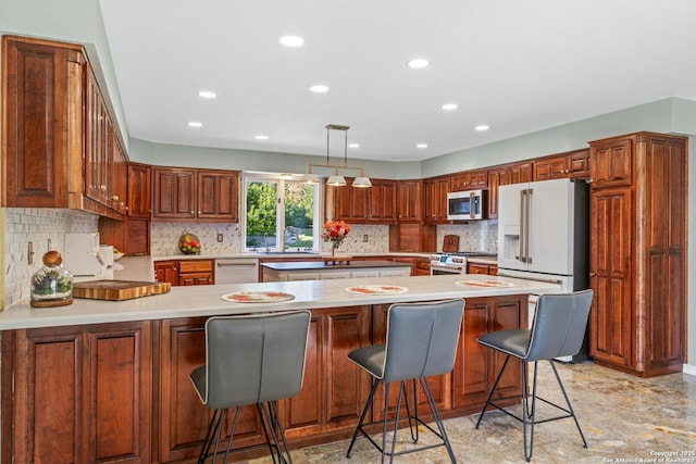 kitchen with a breakfast bar area, appliances with stainless steel finishes, kitchen peninsula, pendant lighting, and sink