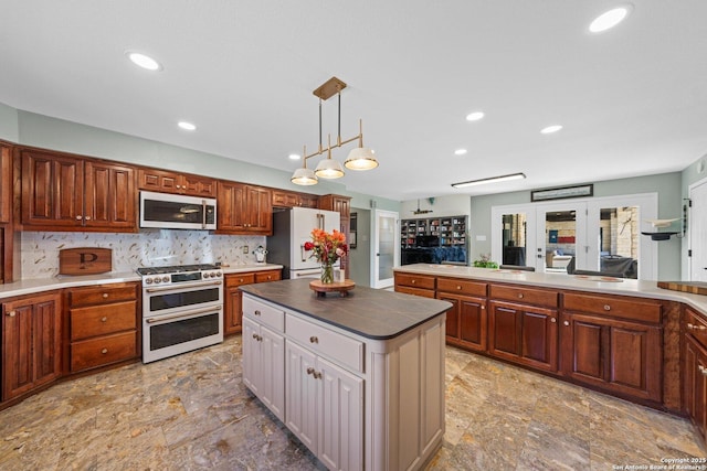 kitchen featuring pendant lighting, double oven range, a center island, tasteful backsplash, and white refrigerator