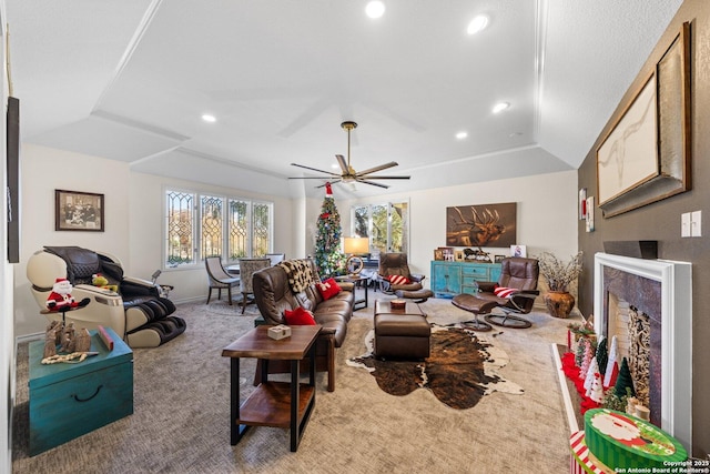 carpeted living room with lofted ceiling, ceiling fan, and a tray ceiling