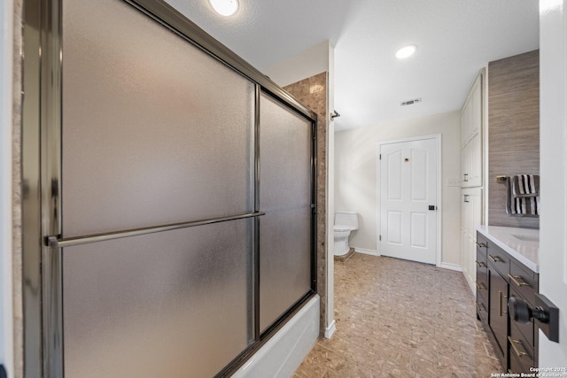 full bathroom with toilet, bath / shower combo with glass door, and vanity