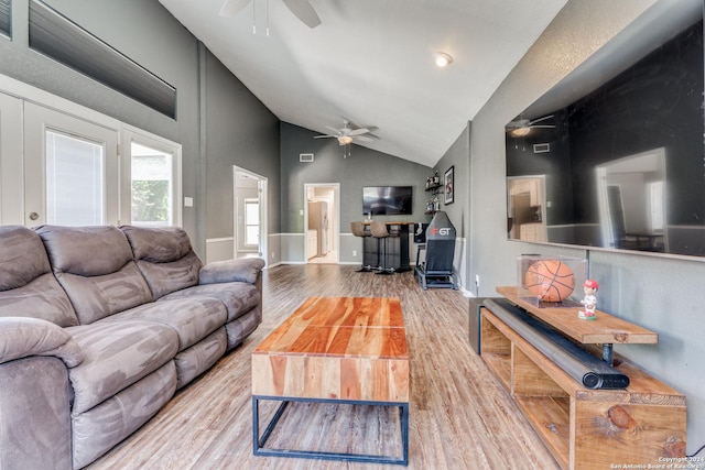 living room featuring light hardwood / wood-style floors, ceiling fan, and high vaulted ceiling