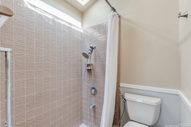 bathroom featuring a shower with shower curtain and toilet