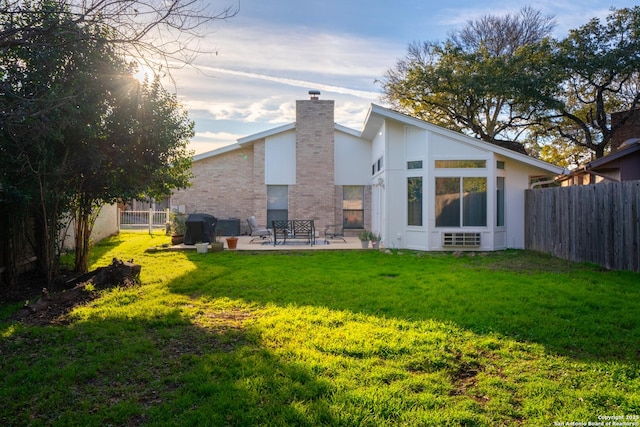 back of property featuring a lawn and a patio area