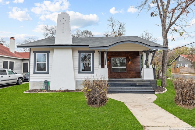 bungalow featuring a porch and a front lawn