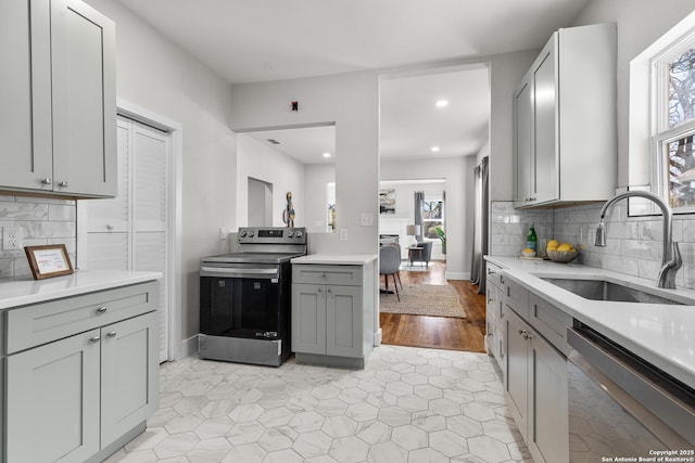 kitchen with tasteful backsplash, stainless steel appliances, gray cabinetry, and sink