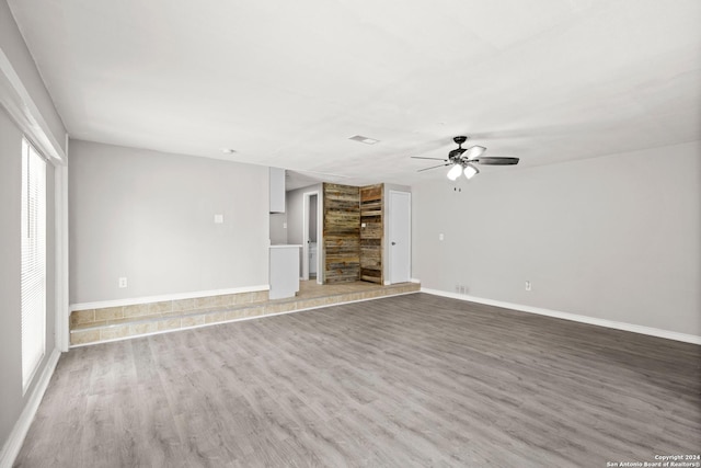 unfurnished living room with ceiling fan and wood-type flooring