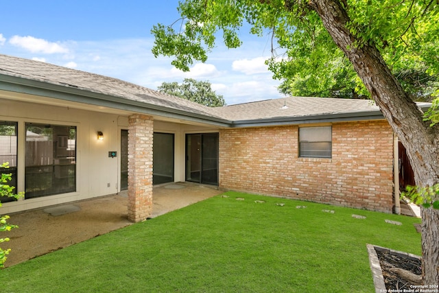 rear view of house featuring a patio area and a yard