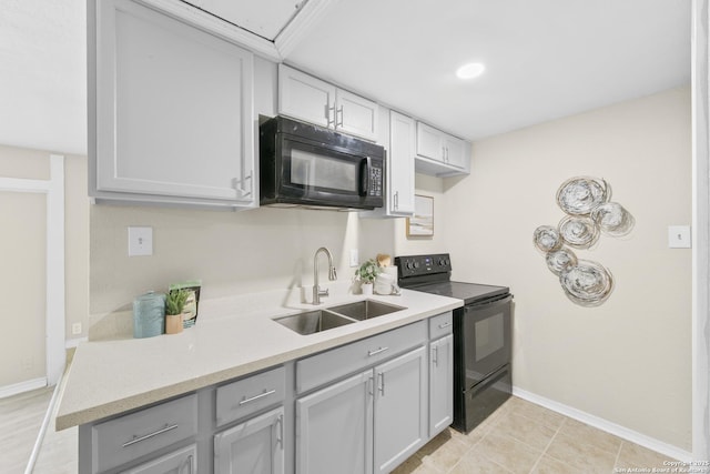 kitchen featuring black appliances, baseboards, light countertops, and a sink