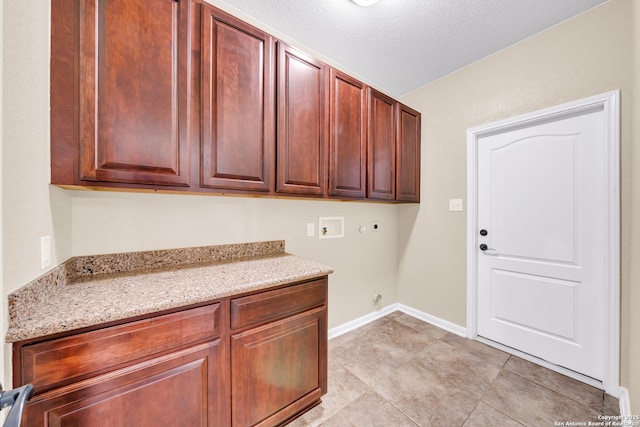 laundry room featuring cabinets, hookup for a washing machine, electric dryer hookup, a textured ceiling, and gas dryer hookup