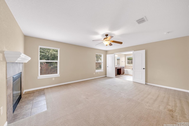 unfurnished living room with light colored carpet, ceiling fan, and plenty of natural light