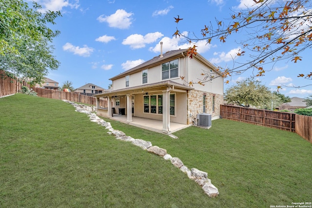 rear view of house with a yard, cooling unit, and a patio area