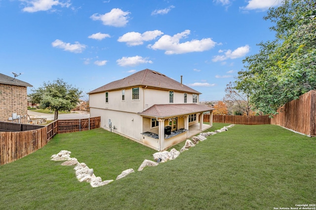 rear view of property with a yard and a patio