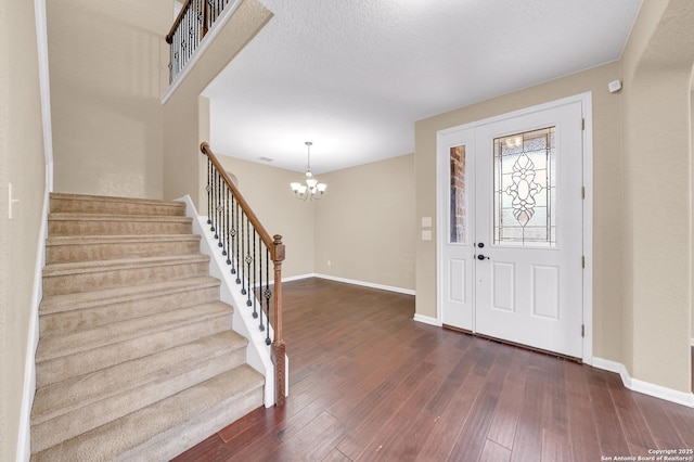 foyer with a chandelier and dark hardwood / wood-style flooring