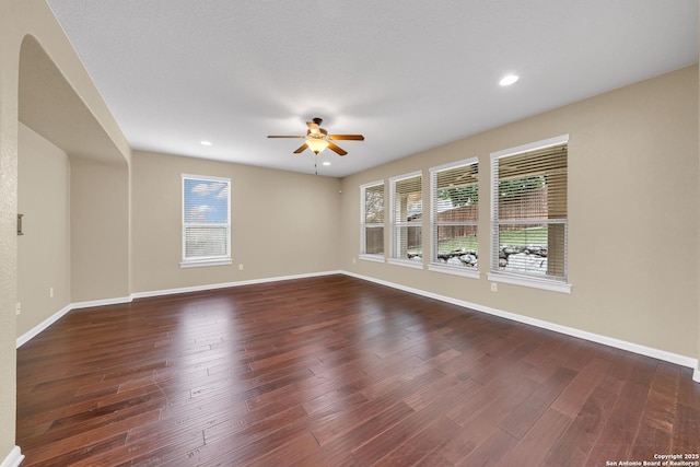 unfurnished room featuring dark wood-type flooring and ceiling fan