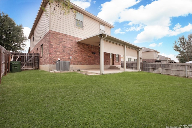 back of property with a yard, central AC unit, and a patio