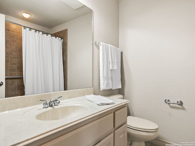 bathroom with toilet, vanity, and walk in shower