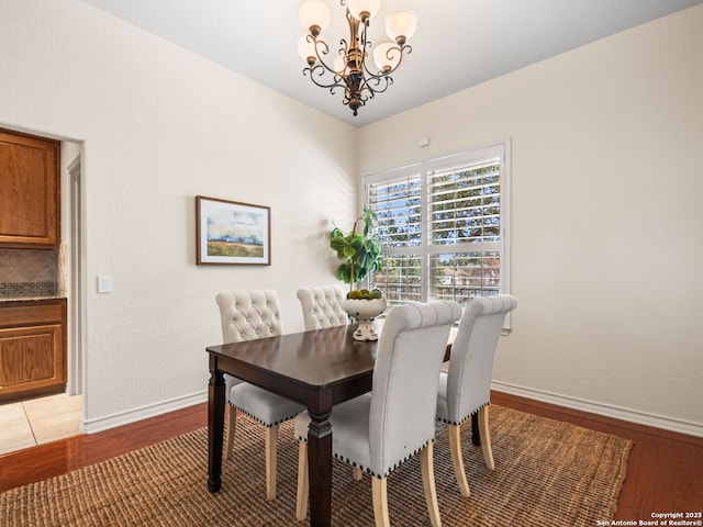 dining area with a notable chandelier and light hardwood / wood-style flooring