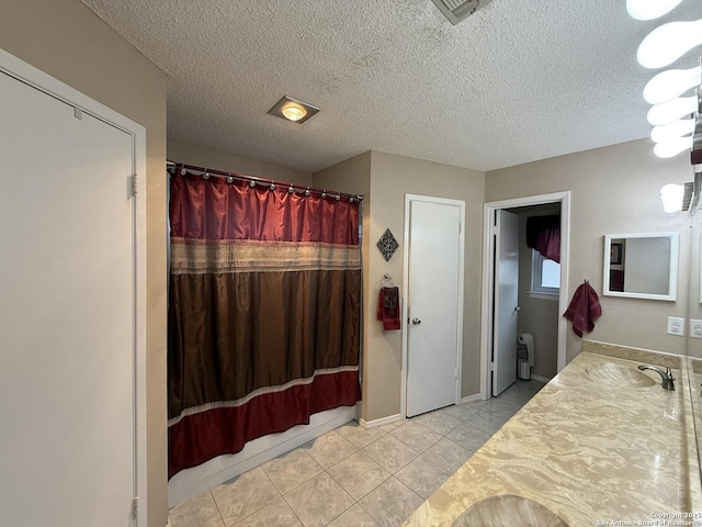 bathroom with vanity, tile patterned flooring, a textured ceiling, and radiator heating unit