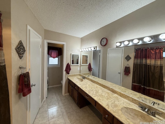 bathroom with lofted ceiling, vanity, toilet, tile patterned floors, and a textured ceiling