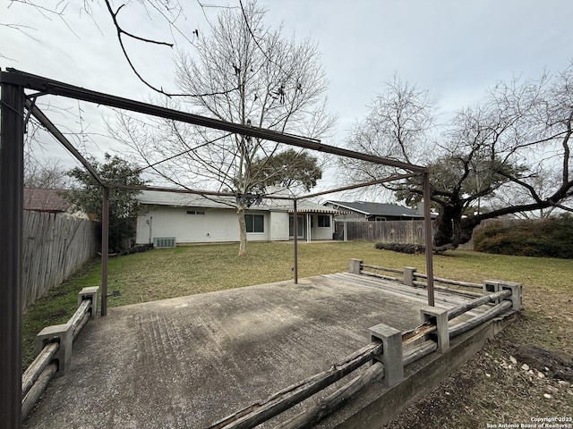 rear view of property with central AC, a patio, and a lawn