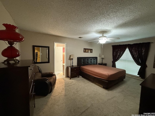 bedroom with connected bathroom, ceiling fan, light colored carpet, and a textured ceiling