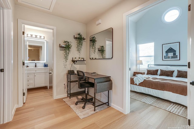 bedroom with ensuite bathroom and light hardwood / wood-style floors