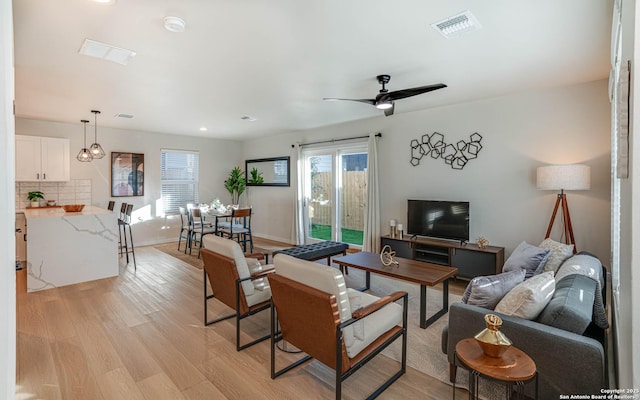 living room with light wood-type flooring and ceiling fan