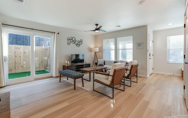 living room featuring ceiling fan, light hardwood / wood-style flooring, and plenty of natural light