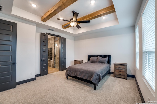 bedroom featuring connected bathroom, beamed ceiling, light colored carpet, ceiling fan, and a raised ceiling