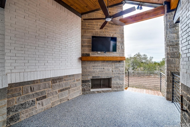 view of patio with ceiling fan and an outdoor stone fireplace