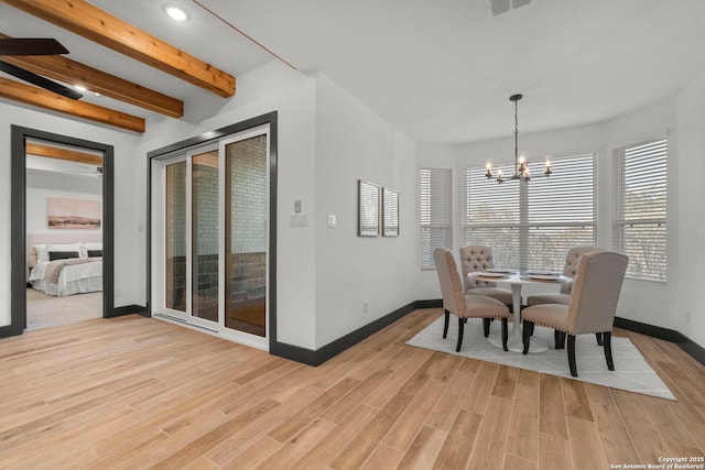 dining room with a notable chandelier, beam ceiling, and light hardwood / wood-style flooring