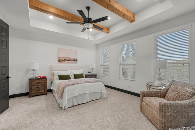 carpeted bedroom featuring a raised ceiling, ceiling fan, and beam ceiling