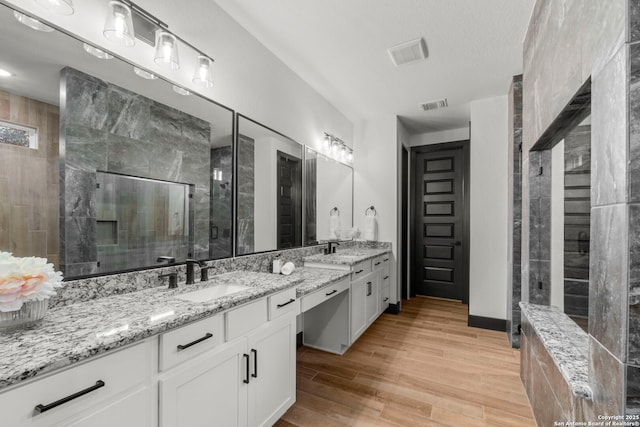 bathroom featuring hardwood / wood-style flooring, vanity, and an enclosed shower