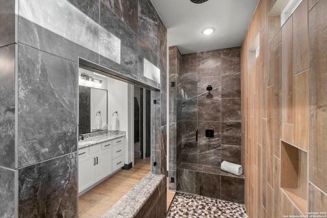 bathroom with vanity, hardwood / wood-style flooring, and a tile shower