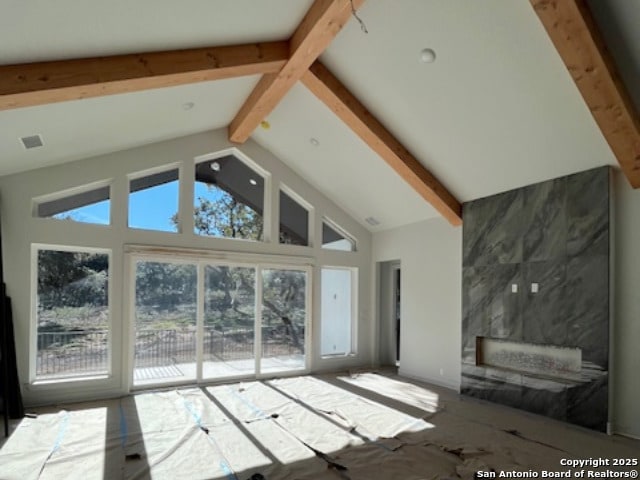 unfurnished living room with vaulted ceiling with beams