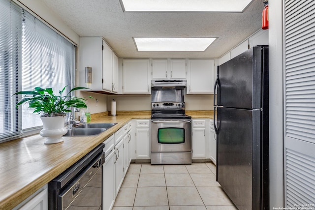 kitchen featuring sink, white cabinetry, a textured ceiling, light tile patterned floors, and black appliances