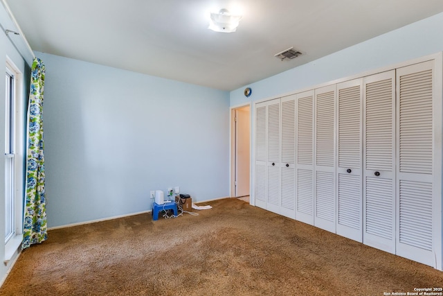 unfurnished bedroom featuring carpet and a closet